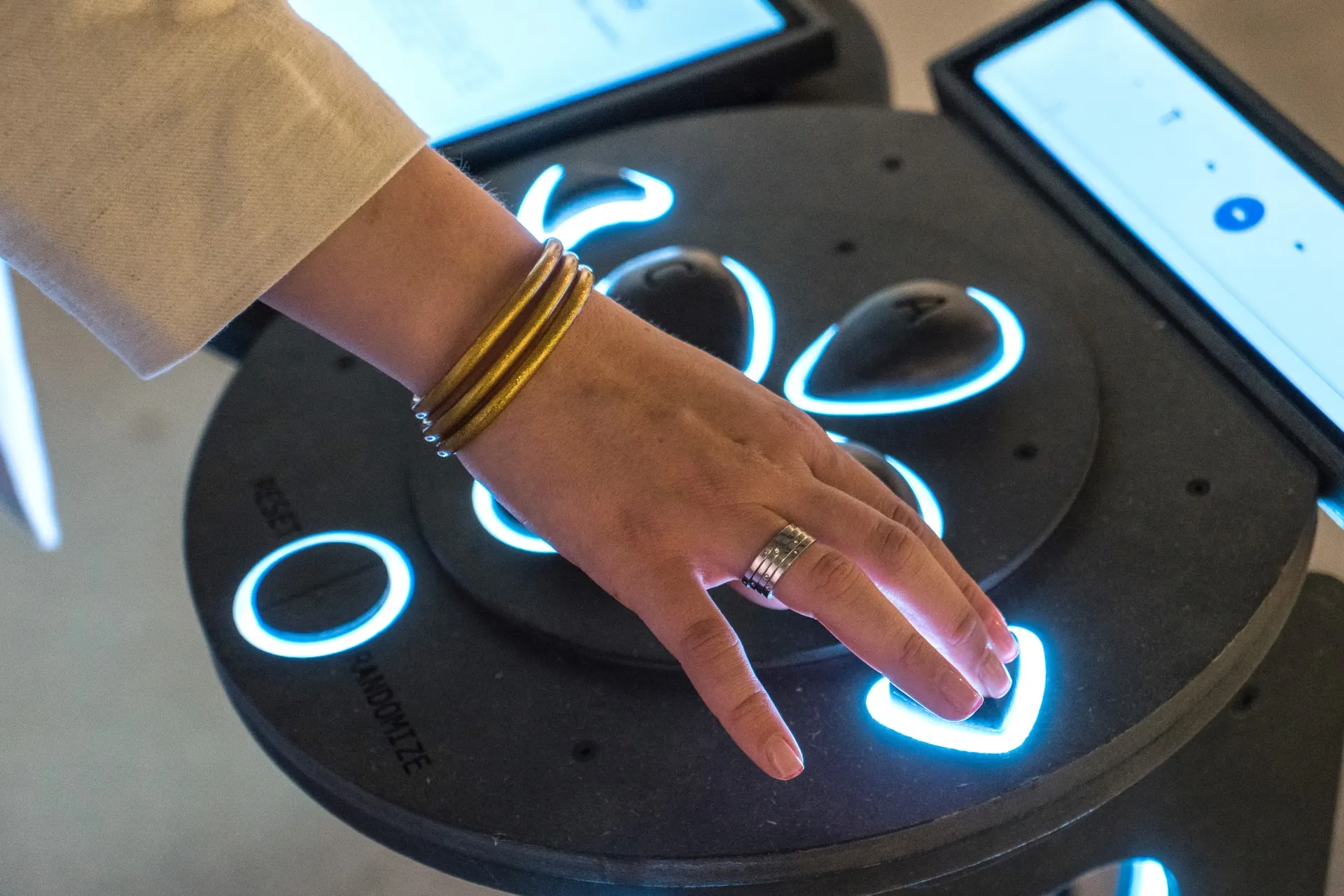 Hand using the illuminated controller of the Life Blocks interactive installation